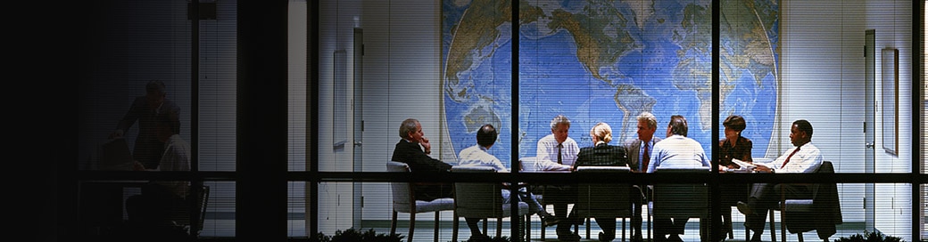 一群会议桌周围的商人，背景上有世界地图