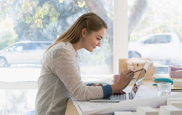 woman at home using a computer at desk