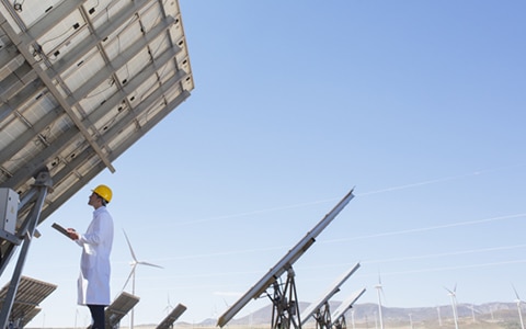 检查人员观察安装在沙漠中的太阳能电池板，对太阳能和风能装置进行预测性维护，以减少风险和停机时间