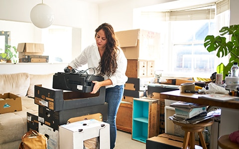 女人打包搬家，如何在搬家前整理和回收你的电子产品