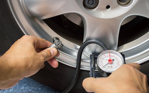 检查轮胎压力的人作为汽车维护的一部分